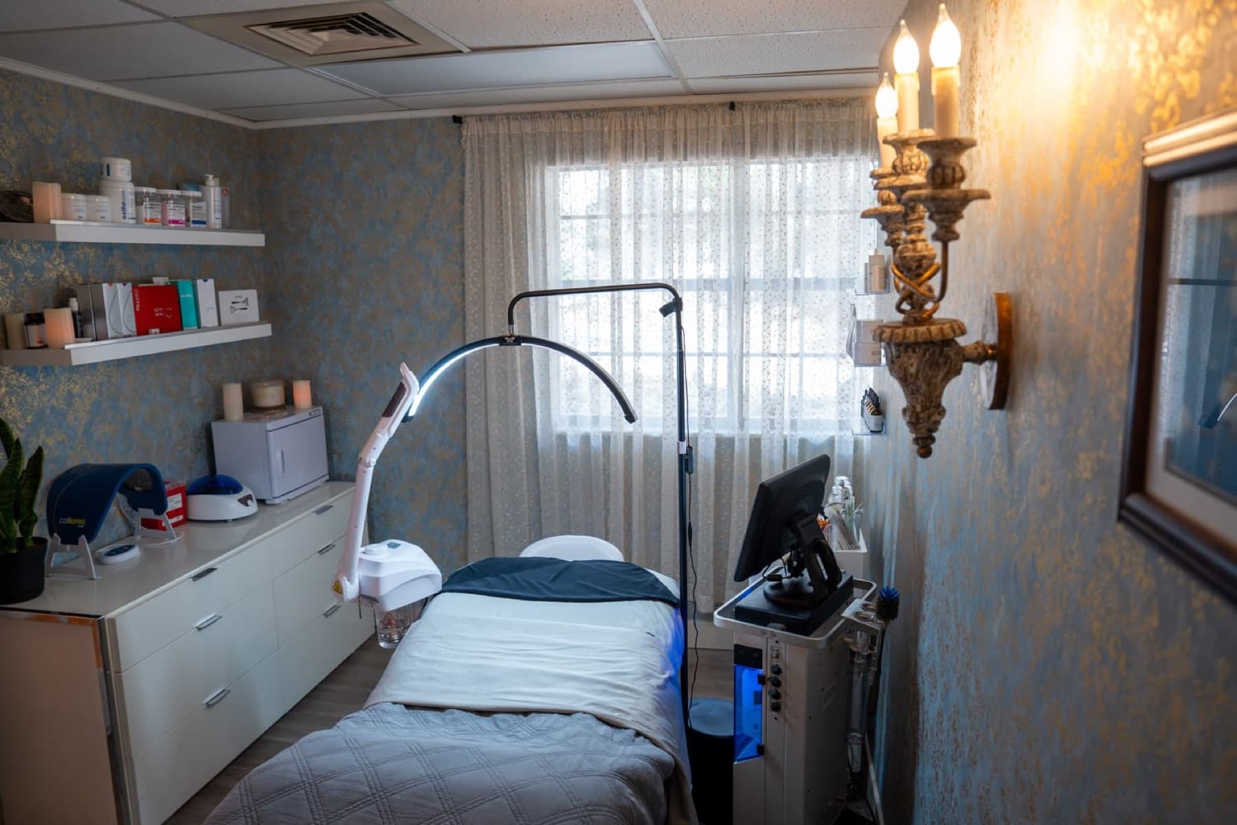 Med spa treatment room with a wall sconce where facial sweating is treated with Botox at LNO Boutique in Centennial, Denver