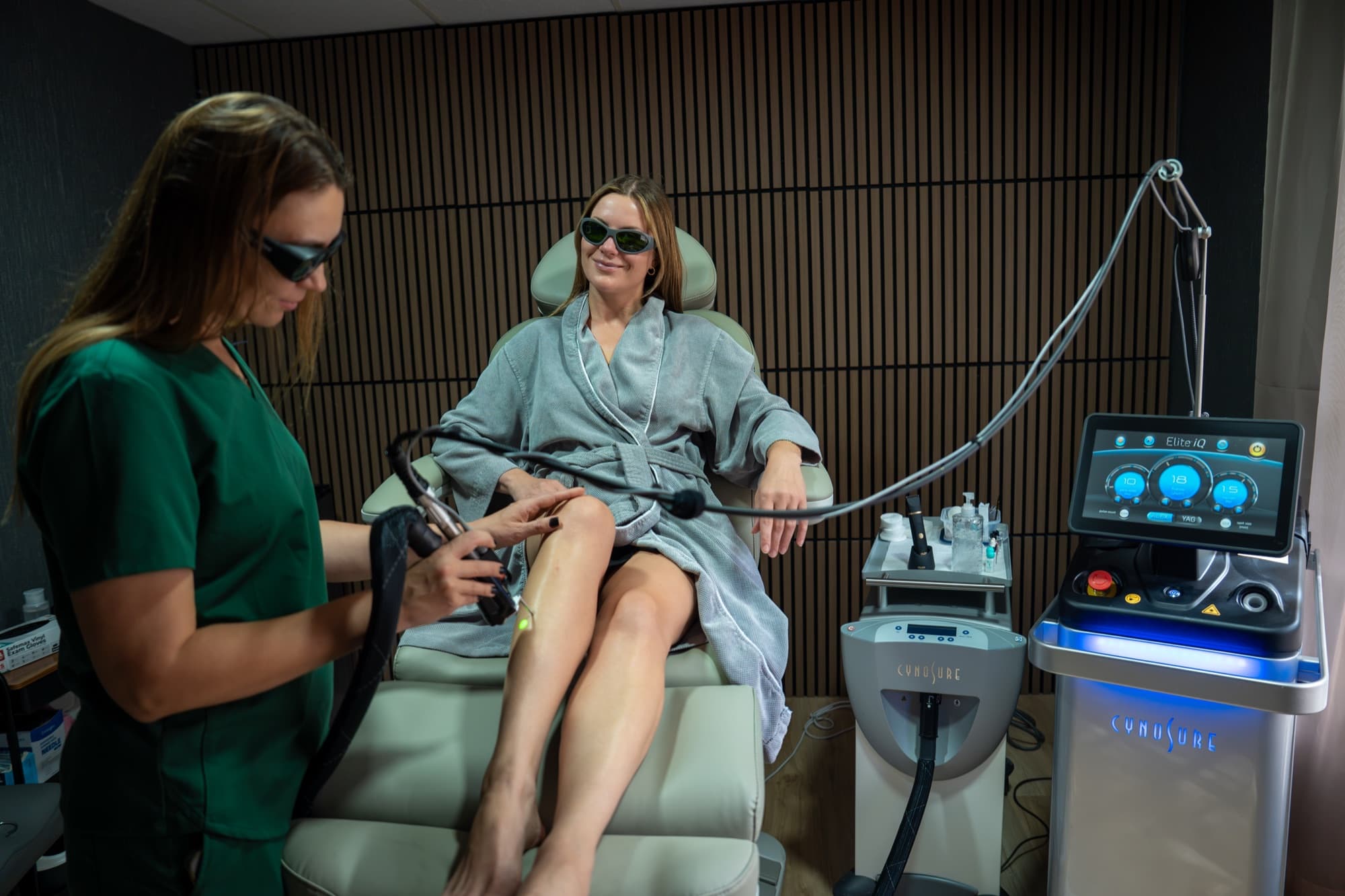 Certified laser technician treating a guest's legs with the Cynosure Elite iQ in the laser treatment chair at LNO Boutique med spa in Centennial, Denver