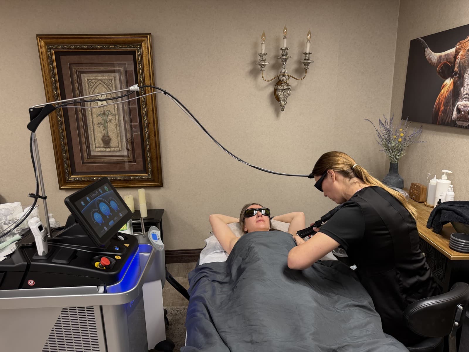 Certified laser technician performing underarm laser hair removal with the Cynosure Elite iQ in the private treatment room at LNO Boutique in Centennial, Colorado