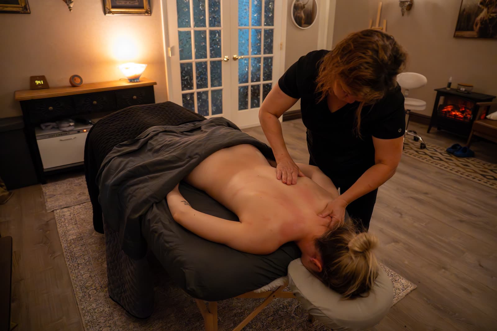 A massage in progress in a softly lit treatment room at LNO Boutique in Centennial